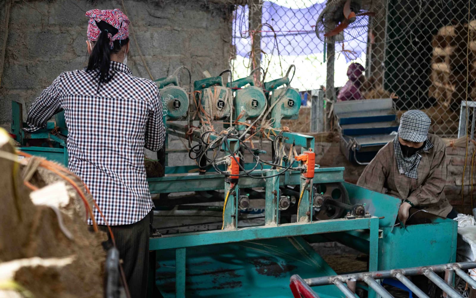 Workers operating industrial processing machinery